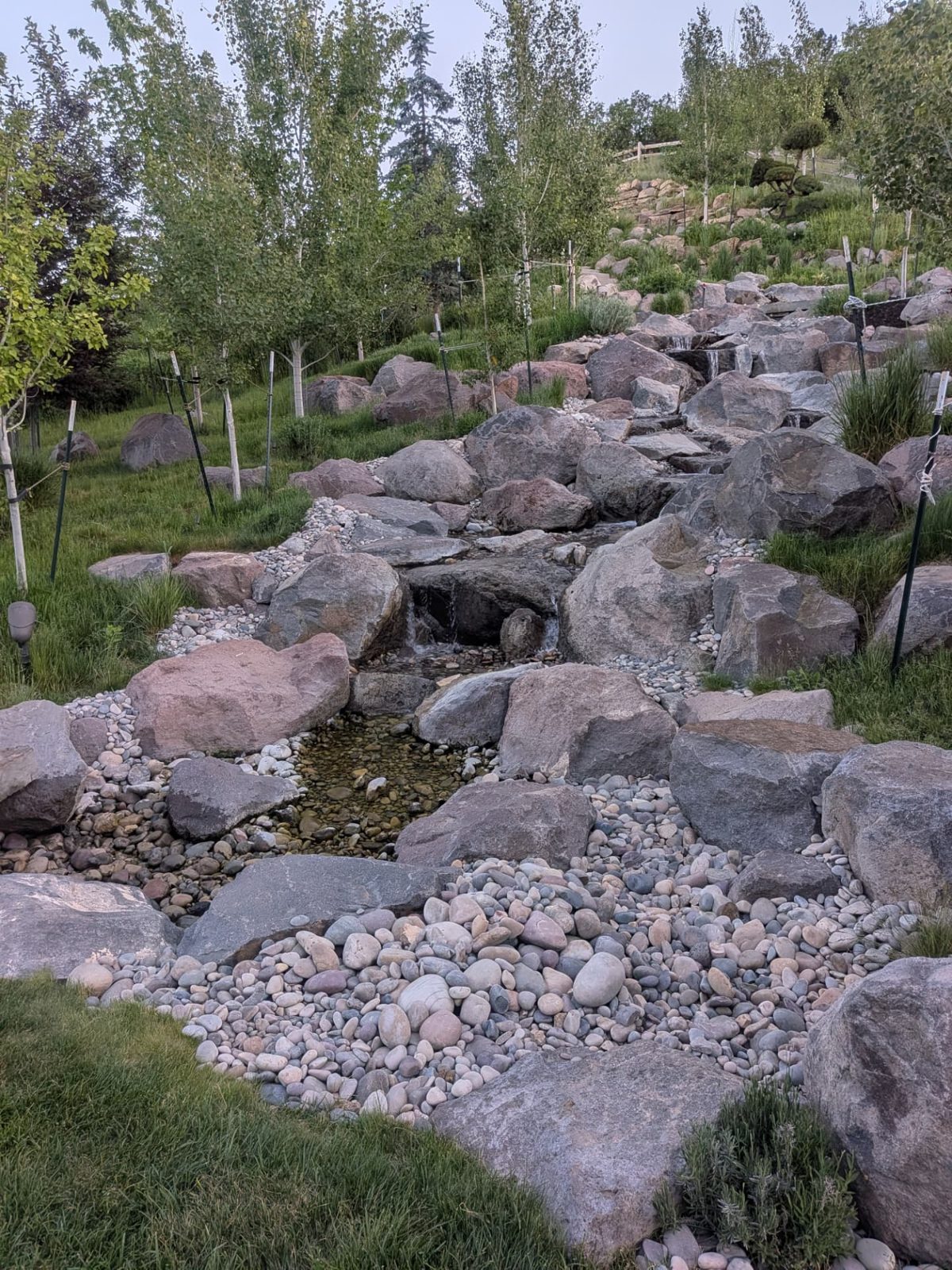 Hillside stream and waterfalls built from natural boulders by Iko Water Gardens